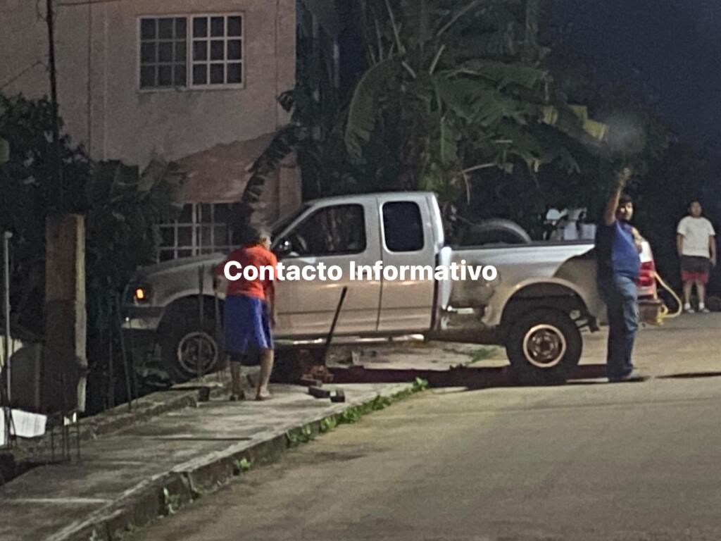 Camioneta a punto de caer en una casa