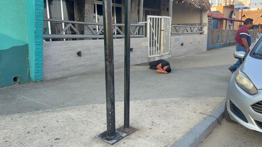 Joven amanece dormido sobre la banqueta afuera de bar en el malecón de Coatzacoalcos