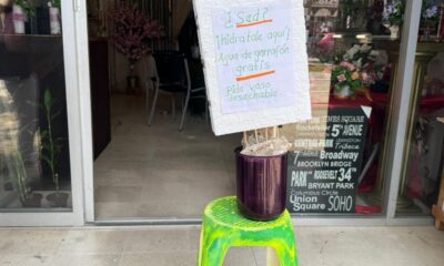 Por las altas temperaturas, una locataria de Coatzacoalcos ofrece vasos de agua a la gente que pasa frente a su negocio
