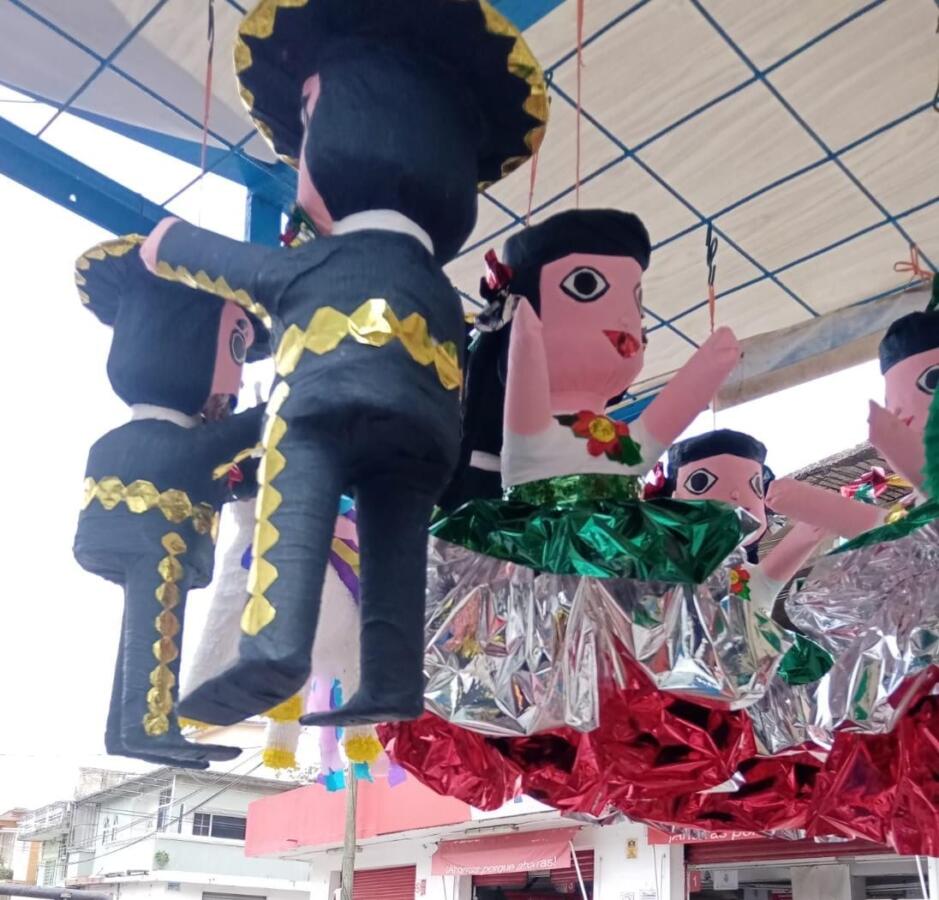 A bordo de un triciclo, una pareja de adultos mayores mantiene vivo su oficio de hacer piñatas en Minatitlán